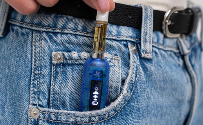 Hand putting the Blue Translucent G Pen 510 Original into a jeans pocket